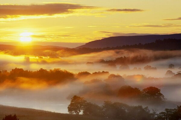 Ognisty świt ponad chmurami z psotną mgiełką