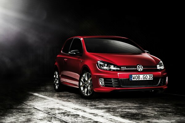 Czerwony volkswagen wyjeżdża z ciemności