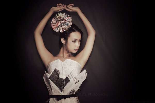 Modelka w sukience z gazety. Ciemne tło