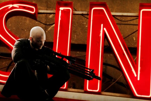 Hitman szuka celu na tle napisu